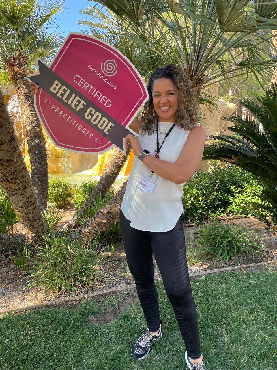 Mariana Guerrero con letrero de certificación Belief Code
